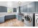 Spacious laundry room featuring blue cabinets, stainless steel sink, and modern washer and dryer at 7830 W Friend Pl, Littleton, CO 80128