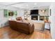 Bright living room featuring a brick fireplace, hardwood floors, and a comfortable leather sofa at 7830 W Friend Pl, Littleton, CO 80128