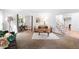 Comfortable living room with a neutral color palette, area rug, and inviting view into dining area and staircase at 7830 W Friend Pl, Littleton, CO 80128