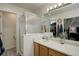 Bathroom featuring a glass-enclosed shower, single sink vanity, and access to a closet at 637 Millet Cir, Brighton, CO 80601