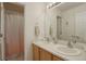 Spacious bathroom featuring double sinks, a large mirror, and shower at 637 Millet Cir, Brighton, CO 80601