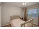 Bedroom featuring a light wood bed frame, window, and bedside table with a lamp at 637 Millet Cir, Brighton, CO 80601