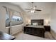 Bedroom featuring a dark wood bed frame, ceiling fan, and a large window with blinds and curtains at 637 Millet Cir, Brighton, CO 80601