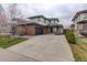 Inviting two-story home with a brick facade and a spacious driveway leading to the attached garage at 637 Millet Cir, Brighton, CO 80601