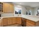 Bright kitchen showcasing wood cabinetry, stainless steel appliances, and a large window above the sink at 637 Millet Cir, Brighton, CO 80601