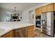 Open kitchen boasts stainless steel appliances, wood cabinets, and a view into the adjacent living room at 637 Millet Cir, Brighton, CO 80601