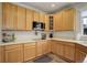 Well-lit kitchen featuring wood cabinets, stainless steel microwave, and ample countertop space at 637 Millet Cir, Brighton, CO 80601