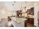 Modern kitchen with granite countertops, stainless steel appliances, dark wood cabinetry, and pendant lighting at 9234 Ridgegate Pkwy, Lone Tree, CO 80124