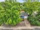 Aerial view of a single-Gathering home surrounded by lush trees and a driveway at 3224 S Dudley St, Lakewood, CO 80227