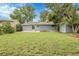 Spacious backyard with green lawn, storage shed, garden, and blue siding on the home at 3224 S Dudley St, Lakewood, CO 80227