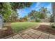 Lush backyard with stone patio, garden beds, fence, and blue-sided house at 3224 S Dudley St, Lakewood, CO 80227