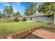 Large green backyard with a fence, garden beds, and blue siding home at 3224 S Dudley St, Lakewood, CO 80227