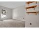 Spacious bedroom with neutral carpeting, a bright window, and decorative shelves at 3224 S Dudley St, Lakewood, CO 80227