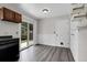 Bright dining area with sliding glass door, wood-look floors, and built-in shelving at 3224 S Dudley St, Lakewood, CO 80227