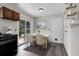 Bright dining area with table, chairs, sliding glass door, wood-look floors, and built-in shelving at 3224 S Dudley St, Lakewood, CO 80227