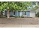 Charming blue single-story home with a well-maintained front yard and mature shade tree at 3224 S Dudley St, Lakewood, CO 80227