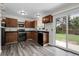 Charming kitchen featuring wood cabinets, black appliances, and a sliding glass door to the backyard at 3224 S Dudley St, Lakewood, CO 80227