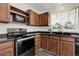 Cozy kitchen featuring sleek black appliances, wood cabinets, and modern countertops at 3224 S Dudley St, Lakewood, CO 80227
