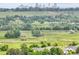 Scenic view of a green field with winding paths, distant city skyline, and trees at 3224 S Dudley St, Lakewood, CO 80227