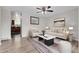 Staged living room featuring wood-look floors, stylish furniture, and contemporary decor accents at 3224 S Dudley St, Lakewood, CO 80227