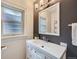 Bathroom with a white vanity, elegant mirror, updated lighting, and a gray accent wall at 586 S Corona St, Denver, CO 80209
