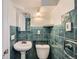 Unique bathroom with teal tiling, a pedestal sink, and modern fixtures offering a stylish space at 586 S Corona St, Denver, CO 80209