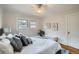 Serene bedroom showcasing soft decor, hardwood floors, and natural light, with a cozy bench at the foot of the bed at 586 S Corona St, Denver, CO 80209