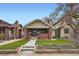 Inviting craftsman home featuring a brick facade, covered porch, and manicured front yard at 586 S Corona St, Denver, CO 80209