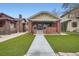 Craftsman style home featuring a brick facade, covered porch, and a lush green lawn at 586 S Corona St, Denver, CO 80209