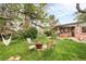 Serene backyard features a fire pit with seating, a hammock, a swing, and green grass at 12193 W New Mexico Pl, Lakewood, CO 80228