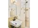 Bathroom features a pedestal sink, updated fixtures, and a tiled shower with storage at 12193 W New Mexico Pl, Lakewood, CO 80228