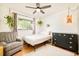 This bedroom features a comfortable armchair, dresser, and plants, creating a cozy and inviting space at 12193 W New Mexico Pl, Lakewood, CO 80228