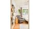 Cozy bedroom features a comfortable armchair, bookshelves and bright window for an airy vibe at 12193 W New Mexico Pl, Lakewood, CO 80228