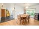 Bright dining area features wood floors, a modern light fixture, and a sliding glass door to the backyard at 12193 W New Mexico Pl, Lakewood, CO 80228