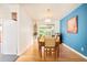 Dining area featuring a wooden table, modern chairs, and a bright blue accent wall at 12193 W New Mexico Pl, Lakewood, CO 80228