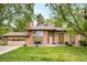 Charming brick home with a two-car garage and a well-manicured lawn surrounded by mature trees at 12193 W New Mexico Pl, Lakewood, CO 80228