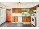 Well-lit kitchen with wood cabinets, a new dishwasher, and an orange-colored door to the outside at 12193 W New Mexico Pl, Lakewood, CO 80228