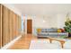 Bright living area with hardwood floors, gray sofa, and modern wooden screen partition at 12193 W New Mexico Pl, Lakewood, CO 80228