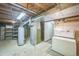 Unfinished basement with exposed ceiling and utilities, including a water heater and chest freezer at 4474 S Vrain St, Denver, CO 80236