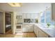 Bright kitchen with white cabinets, modern appliances, and a large window providing ample light at 4474 S Vrain St, Denver, CO 80236