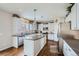 Bright kitchen featuring white cabinets, stainless steel appliances, an island, and hardwood floors at 14096 Roaring Fork, Broomfield, CO 80023