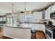 Open kitchen with island, white cabinets, stainless steel appliances and a breakfast bar at 14096 Roaring Fork, Broomfield, CO 80023