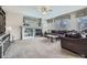 Cozy living room with a fireplace, built-in shelving, plush carpet, and large windows at 14096 Roaring Fork, Broomfield, CO 80023
