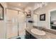 Clean bathroom with a walk-in shower, granite countertop, and dark vanity at 16546 Umatilla Pl, Broomfield, CO 80023