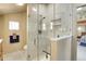 Tiled shower with glass door, tiled shower niche, and bathroom area with decorative wall art at 6360 S Gibraltar Cir, Centennial, CO 80016