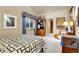 Well-lit bedroom with a patterned quilt, dark wood furniture, and a window with light-blocking curtains at 6360 S Gibraltar Cir, Centennial, CO 80016