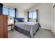Bedroom with a queen bed, two windows, gray carpet, and blue accents at 6360 S Gibraltar Cir, Centennial, CO 80016
