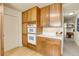 Kitchen with wood cabinets, modern appliances, and a hallway view at 6360 S Gibraltar Cir, Centennial, CO 80016