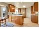 Bright kitchen featuring wood cabinets, white countertops, and a center island with a cooktop at 6360 S Gibraltar Cir, Centennial, CO 80016