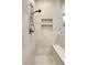 Shower with tiled walls, built-in shelving, and bench seat at 6360 S Gibraltar Cir, Centennial, CO 80016